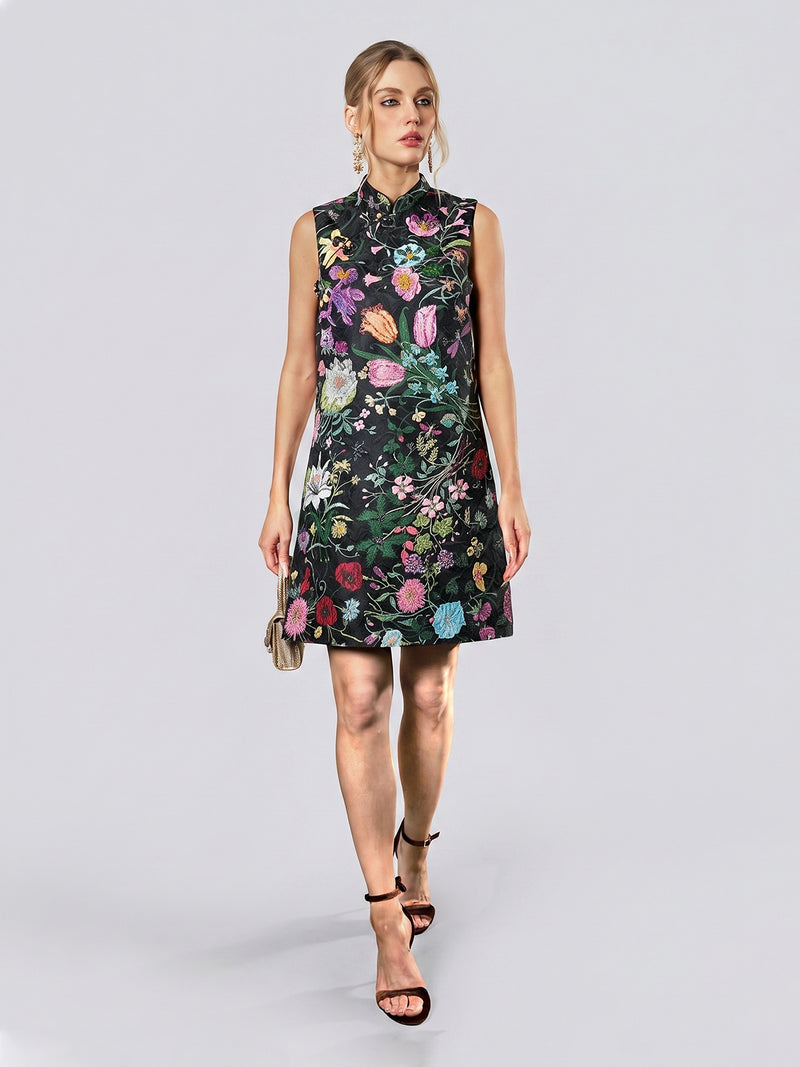 A woman dressed in the Social Queen Colorful Floral Mandarin Collar Dress—featuring a sleeveless silhouette, high neckline, and vibrant floral jacquard pattern—carries a small purse and walks in black heels against a plain light background.