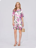 A woman stands against a plain background, wearing the Social Queen Floral Print Lace Shift Mini Dress—a short-sleeve, knee-length dress with a subtle shift silhouette—paired with heeled sandals and carrying a beaded handbag.
