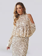 A woman models the Social Queen Beaded Sequin Cold Shoulder Top, styled as a dress and adorned with shiny, light-colored sequins, set against a plain background.