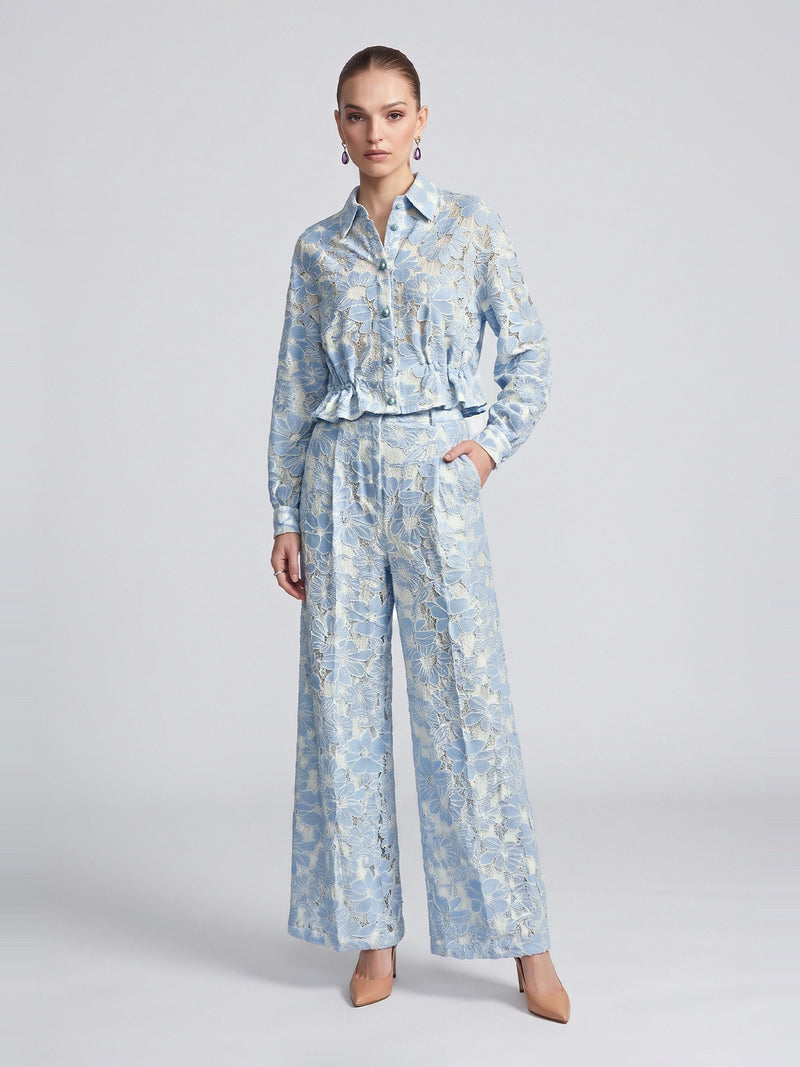 A model wearing a Social Queen Floral Lace Cropped Jacket in light blue and white with matching high-waisted wide-leg trousers.