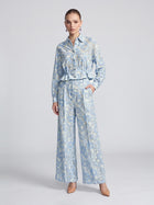 A model wears a light blue openwork floral lace long-sleeve button-up shirt with a ruffled hem paired with matching Floral Lace Wide-Leg Pants.