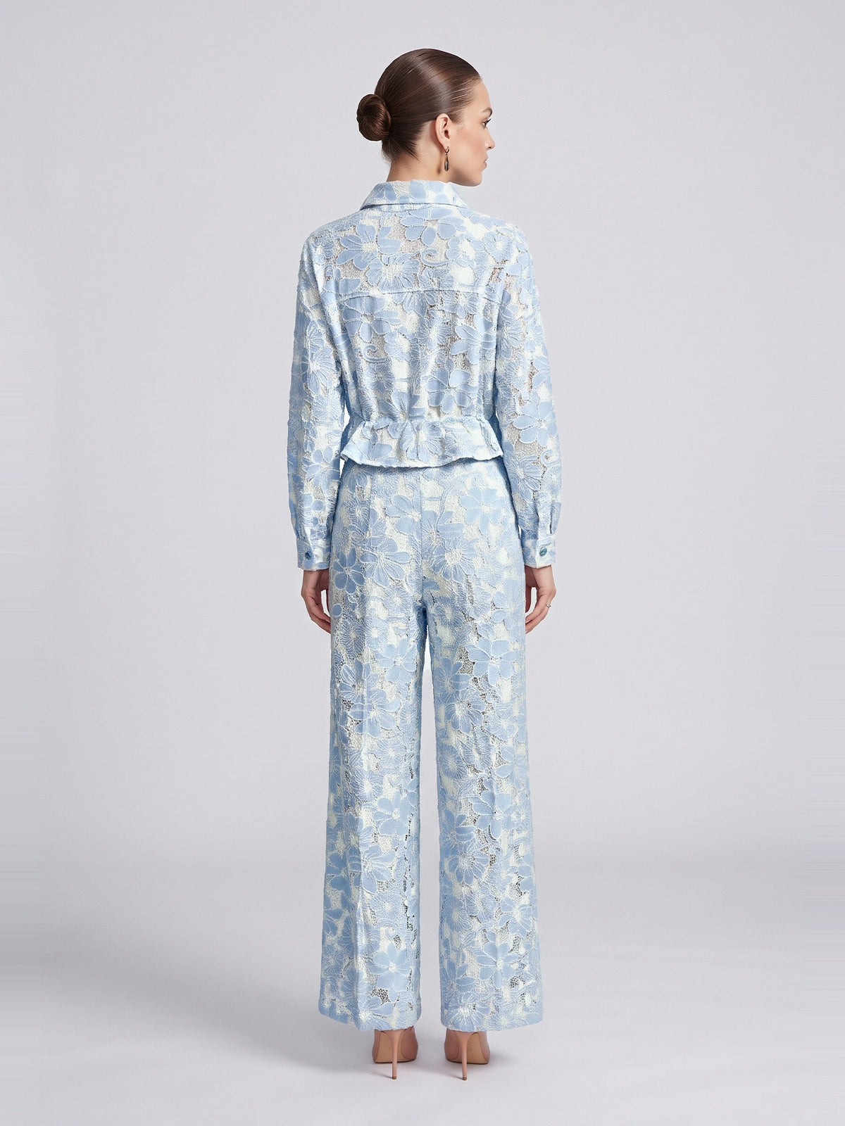 Back view of a person wearing a light blue, floral lace Floral Lace Cropped Jacket and matching wide-leg trousers.