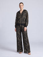 A model wears a Social Queen Paisley Embroidered Lace Hooded Jacket and matching wide-leg trousers, both featuring intricate gold-tone paisley embroidery in cutout lace.