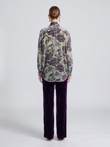 A person seen from behind wears a green, sheer long-sleeved shirt with a purple floral print and purple Velvet Wide-Leg Pants.