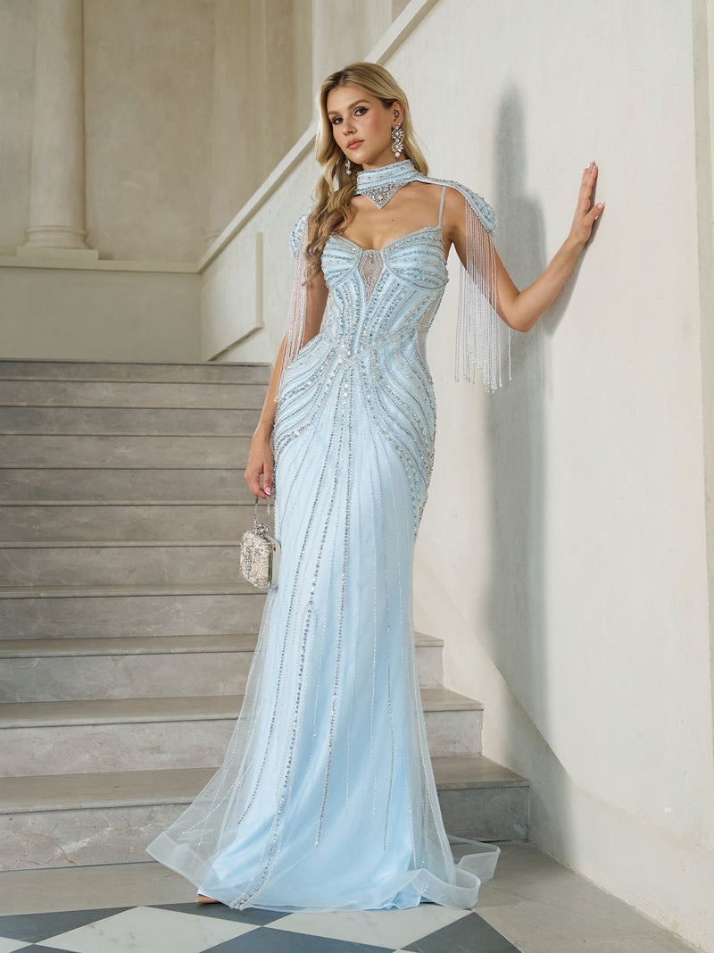 A woman stands on stairs wearing the Social Queen Artisanal Beaded Fringe High-Neck Gown, a fitted light blue evening dress with sheer panels, cape sleeves, fishtail hem, matching choker, and holding a small silver purse.