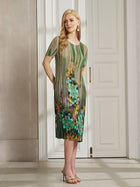 A woman stands indoors wearing the Social Queen Artistic Smudge Print Plissé Dress, a knee-length, short-sleeved silk piece with an artistic pattern—ideal for resort wear—paired with beige high-heeled sandals.