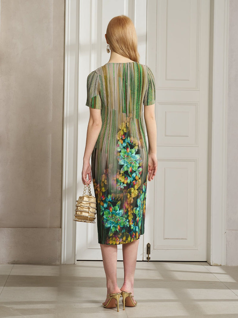 A woman with long red hair stands by a white door, wearing Social Queen's Artistic Smudge Print Plissé Dress and holding a small gold handbag—an elegant choice for chic resort style.