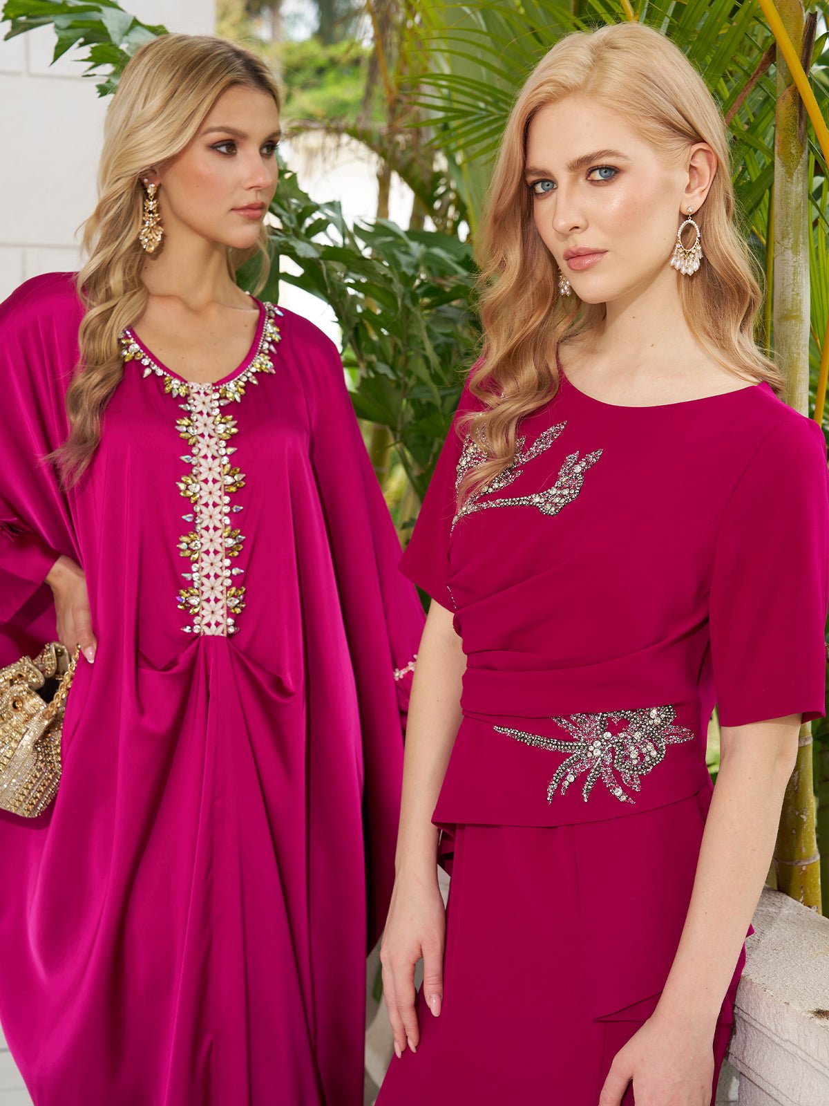 Two women in Social Queen's Asymmetric Beaded Mermaid Slit Dress stand before green plants, each accessorized with gold earrings.