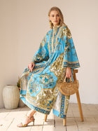 A woman wearing the Social Queen Baroque Engineered-Print Cotton Dress sits on a wooden stool holding a wooden handbag, with a ceramic vase in the background.