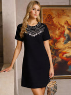 A woman wearing the Social Queen Beaded Collar A-Line Mini Dress stands indoors with a small handbag, a classical painting visible in the background.