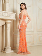 A woman stands indoors wearing the Social Queen Beaded Crystal Strapless Gown, featuring a fitted silhouette and sparkling embellishments, while looking over her shoulder.