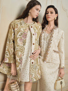 Two women wearing Social Queen's Beaded Floral Embroidered Tweed Jacket in cream and gold, styled with jewelry and handbags, stand against a light-colored wall.