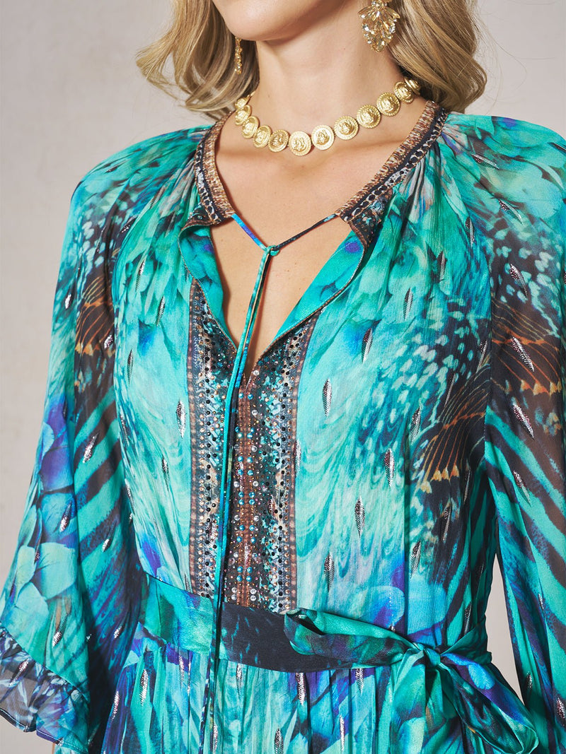 Woman wearing the Social Queen Beaded Floral Print Ruffled Dress, paired with a gold coin necklace and large gold earrings.