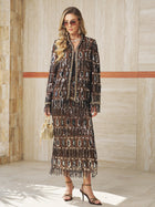 A woman stands indoors wearing the Beaded Fringe Sequin Midi Skirt by Social Queen, styled with sunglasses, heeled sandals, and a small gold handbag.