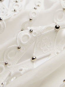Close-up of Social Queen’s Beaded Geometric Lace Blouse, showcasing white fabric with hand-crocheted lace, embroidered patterns, and silver studs—ideal for a vintage-inspired look.