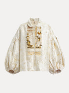 The Beaded Jacquard Lantern Sleeve Jacket by Social Queen features cream and gold floral jacquard, a collar, lantern sleeves, and ornate hand-applied beads on the front placket.