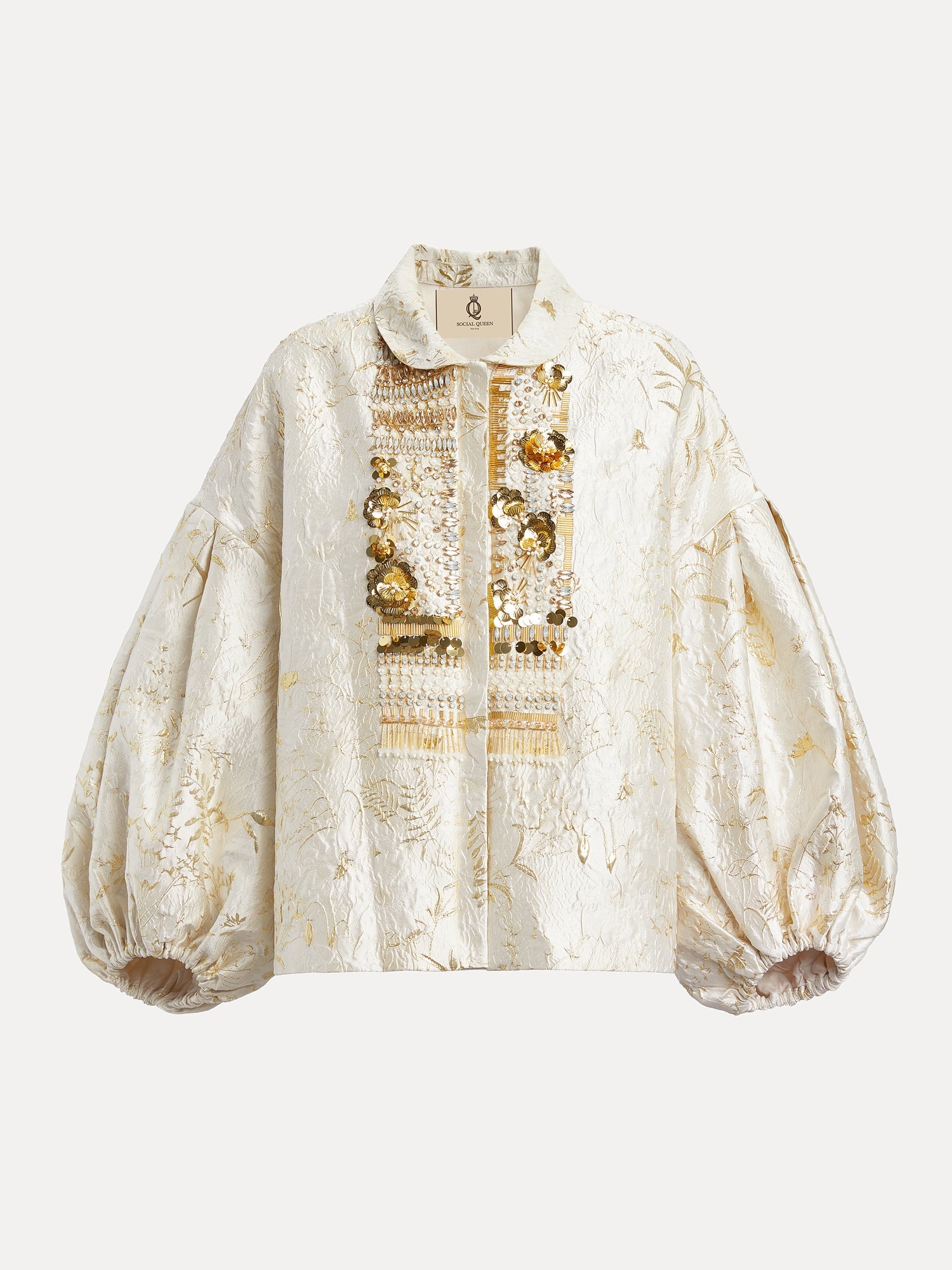 The Beaded Jacquard Lantern Sleeve Jacket by Social Queen features cream and gold floral jacquard, a collar, lantern sleeves, and ornate hand-applied beads on the front placket.