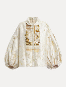 The Beaded Jacquard Lantern Sleeve Jacket by Social Queen features cream and gold floral jacquard, a collar, lantern sleeves, and ornate hand-applied beads on the front placket.