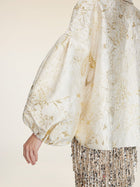 Wearing the Social Queen Beaded Jacquard Lantern Sleeve Jacket paired with a skirt adorned in metallic and sequin fringe.