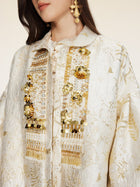 A woman wears the Social Queen Beaded Jacquard Lantern Sleeve Jacket, featuring hand-applied beads and gold accents, paired with gold drop earrings.