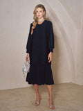A woman stands indoors wearing the Social Queen Beaded Jacquard Pleated Midi Dress, styled with a silver necklace, silver heels, and a small silver handbag.