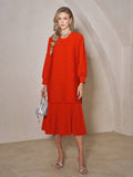 A woman stands indoors wearing the Social Queen Beaded Jacquard Pleated Midi Dress in red, styled with silver sandals, a silver necklace, and a small silver handbag.