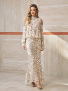 A woman stands indoors wearing the Social Queen Beaded Sequin Mermaid Elastic Skirt, styled with long sleeves, a high neckline, and gold sandals.