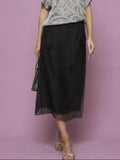A person wears the Social Queen Beaded Silk Organza Midi Skirt, styled with a grey short-sleeve knit top. Only the lower half is visible against a mauve background.