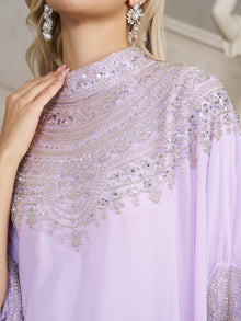 A close-up shows a person in the Social Queen Beaded Tulle Caftan Cape Dress, featuring delicate beads and silver sequins, paired with matching earrings and manicured nails.