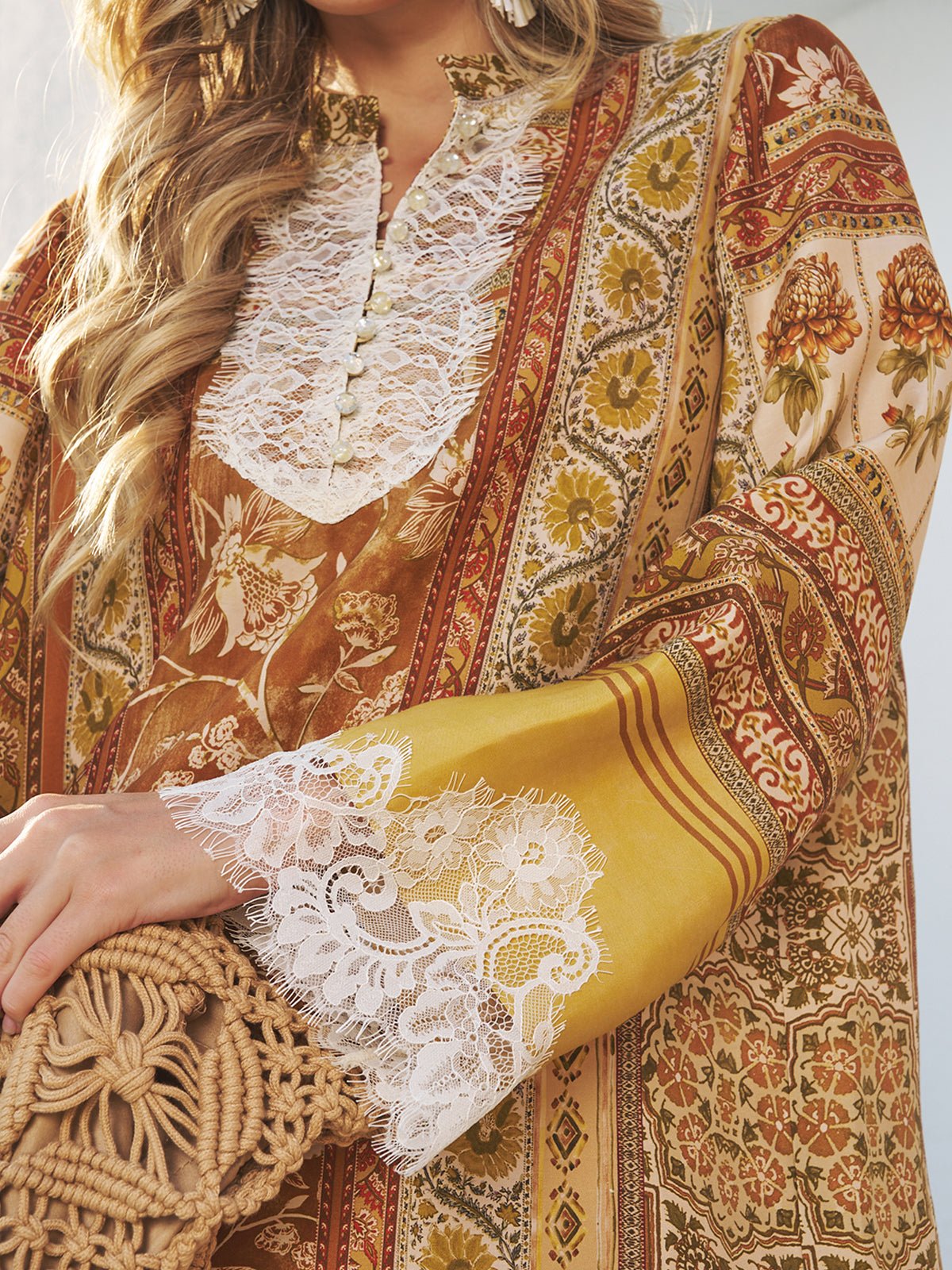 A woman, partially visible, wears the Social Queen Boho Lace Floral Print Dress featuring handcrafted lace panels and a botanical motif, paired with a woven bag.