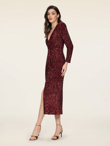 A woman wears the Social Queen Burgundy Sequin V-Neck Slit Dress with a ruched waist and gold open-toe heels against a plain light background.