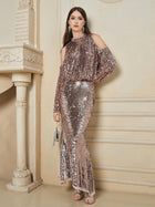 A woman stands indoors wearing the Social Queen Champagne Sequin Mermaid Skirt, featuring metallic sequins and a fishtail silhouette, accessorized with a small silver bag and silver sandals.