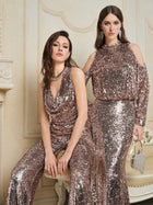 Two women pose indoors in sparkling rose gold outfits; one wears Social Queen's Champagne Sequin V-Neck Cami Top with a skirt and a silver purse, while the other is styled in a draped jumpsuit.
