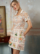 A woman poses indoors by a wooden table and framed art, wearing the Social Queen Contrast Floral Embroidered Mini Dress featuring a fitted straight silhouette and white collar.