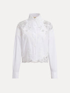 The Cropped Embroidered Lace Panel Blouse by Social Queen features long sleeves, a high collar, button-down front, and hand-stitched floral lace detailing on the chest and sleeves.