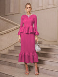Wearing the Social Queen Crystal-Embellished Pleated Peplum Set, she stands on stone stairs with a silver handbag and strappy heels—a stylish pick for a wedding guest.