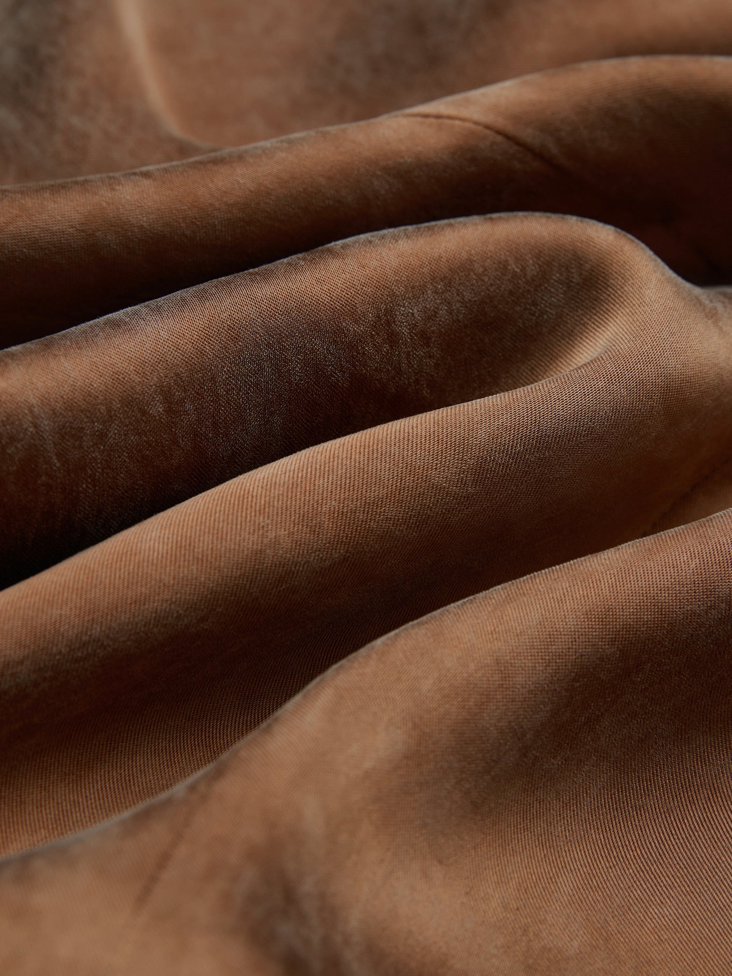 Close-up of soft, brown velvet fabric with visible folds and subtle sheen, echoing the luxurious look of Social Queen’s Crystal-Embellished Tencel Satin Blouse.