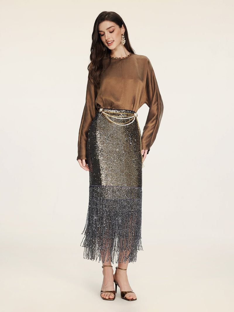 A woman in a Social Queen Crystal-Embellished Tencel Satin Blouse, metallic sequin fringe skirt, gold chain belt, and heeled sandals stands against a plain light background.