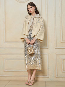 A woman stands indoors against a decorative wall, wearing the Social Queen Crystal Leaf Embroidered Wool Coat.