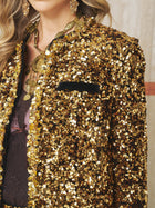 A person wearing the Social Queen Crystal-Trim Sequin Velvet Jacket, layered necklaces, earrings, and a dark lace top, shown from shoulders to waist.