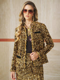 A woman in sunglasses models the Social Queen Crystal-Trim Sequin Velvet Jacket with a matching skirt, posing against a beige wall.