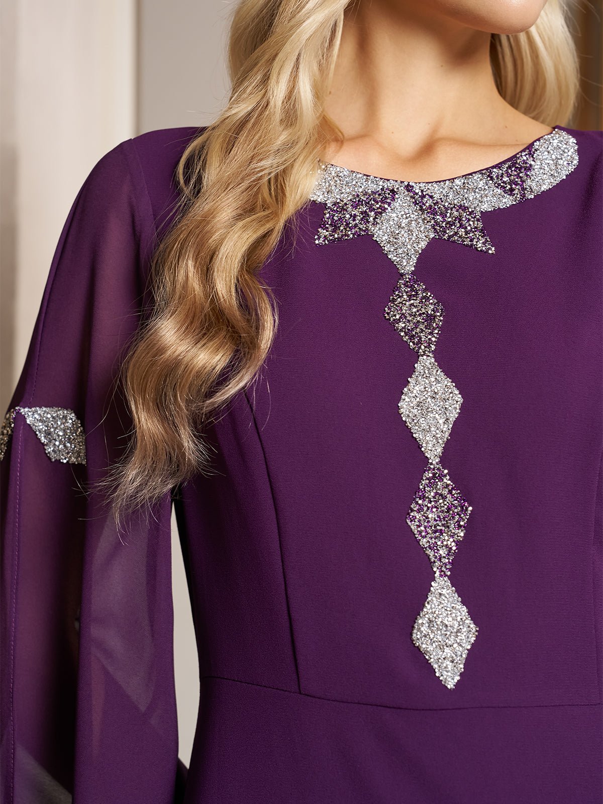 A woman with long blonde hair wears the Social Queen Elegant Beaded Split-Sleeve Dress, a purple high-waist A-line evening dress with silver diamond-shaped embellishments on the front and sleeves.