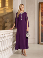A woman in the Elegant Beaded Split-Sleeve Dress by Social Queen stands indoors by a white railing, holding a small silver handbag and wearing silver sandals.