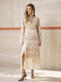 A woman wears the Social Queen Embroidered Fringe Lace Crystal-Trimmed Dress indoors, styled with heeled sandals and statement earrings on a light-tiled floor.