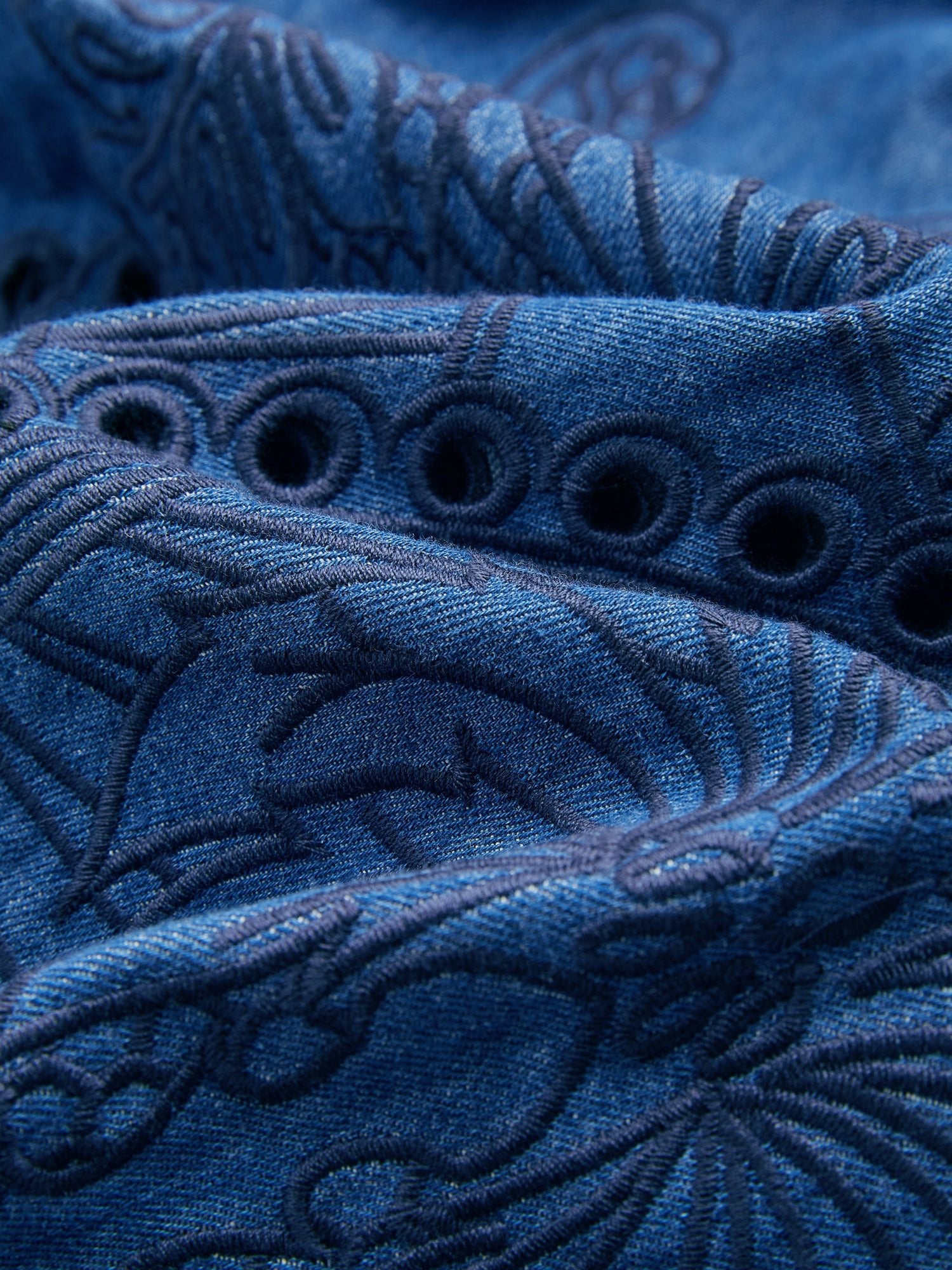 Close-up of Social Queen's Embroidered Jacquard Denim Dress, showcasing floral jacquard embroidery and circular cut-out details on blue denim fabric.