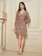 A woman stands indoors wearing the Social Queen Embroidered Sequin Tassel Mini Dress, accessorized with a small clutch and strappy heels.