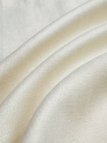 Close-up of the Embroidered Wool Jacket with Pearl Accents by Social Queen, featuring smooth cream fabric, gentle folds, subtle sheen, and delicate hand-embroidered floral motifs.