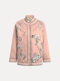 The Floral Embroidered Beaded Jacket by Social Queen features a light pink, long-sleeved stand collar design with white and black hand-embroidered floral motifs and decorative edge trim.