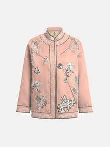 The Floral Embroidered Beaded Jacket by Social Queen features a light pink, long-sleeved stand collar design with white and black hand-embroidered floral motifs and decorative edge trim.