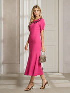 A woman wears the Social Queen Floral Embroidered Beaded Mermaid Dress indoors, featuring 3D floral appliqué on the shoulder, paired with a small handbag and gold heels.